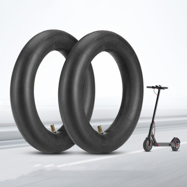 Two black scooter tires with a small electric scooter on a light gray background