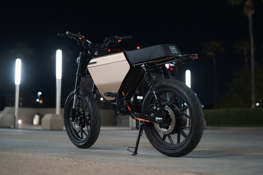 Motorcycle on a road at night with streetlights in the background