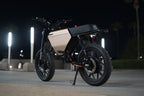 Motorcycle on a road at night with streetlights in the background